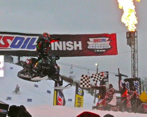 Tuckeer Hibbert flies past torches, snow piles, and the checkered flag to win the Duluth AMSOIL SnoCross.